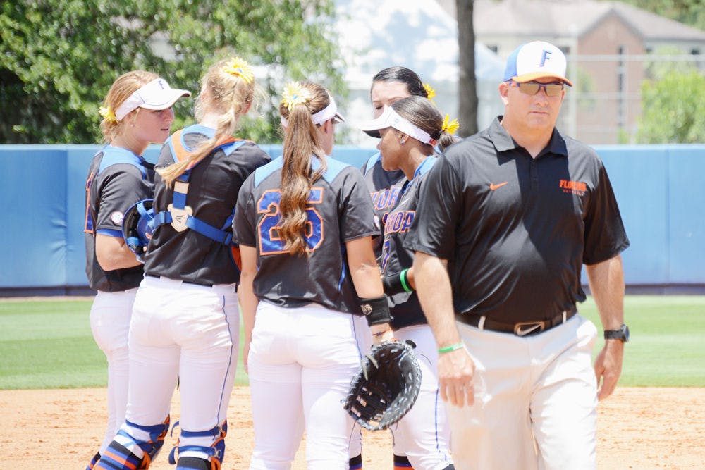 UF softball coach Tim Walton (right) walks away as his infielders huddle prior to Florida's 2-1 win against Florida Atlantic in the 2015 NCAA Super Regionals at Katie Seashole Pressly Stadium.