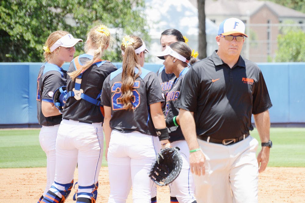 <p>UF softball coach Tim Walton (right) walks away as his infielders huddle prior to Florida's 2-1 win against Florida Atlantic in the 2015 NCAA Super Regionals at Katie Seashole Pressly Stadium.</p>