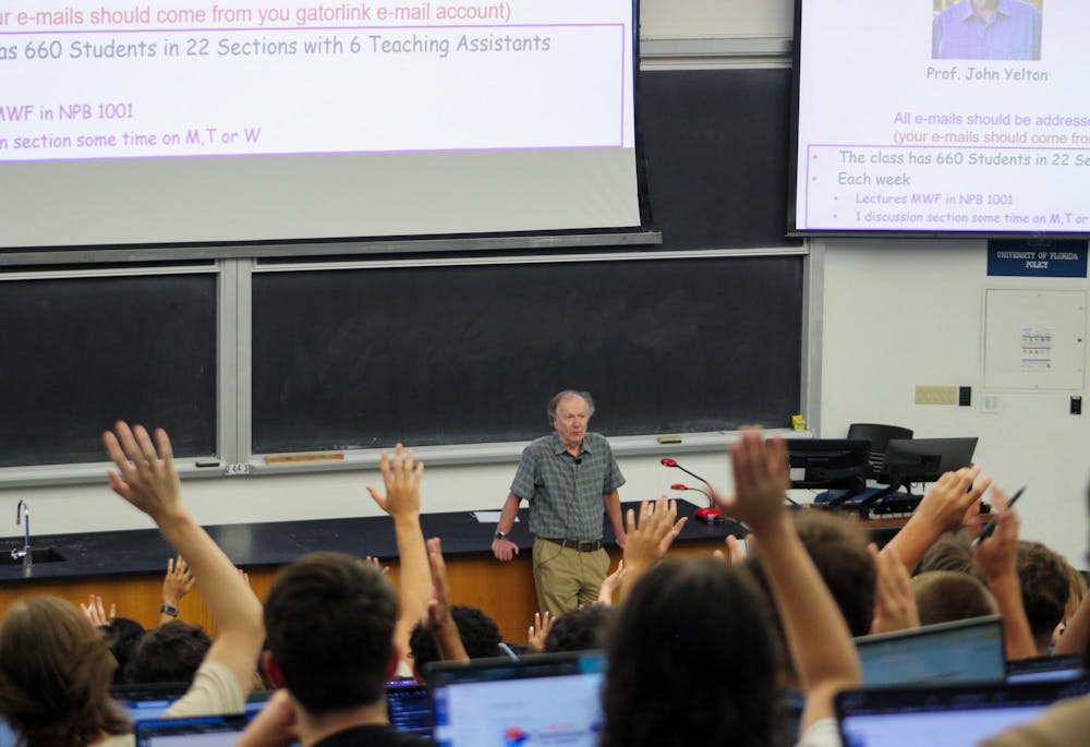 Students raise their hands in Professor John Yelton's lecture at the New Physics Building, Friday, August 21, 2026, in Gainesville, Fla.