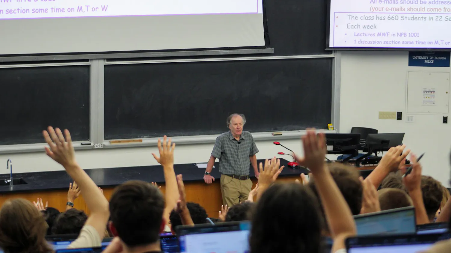 Students raise their hands in Professor John Yelton's lecture at the New Physics Building, Friday, August 21, 2026, in Gainesville, Fla.