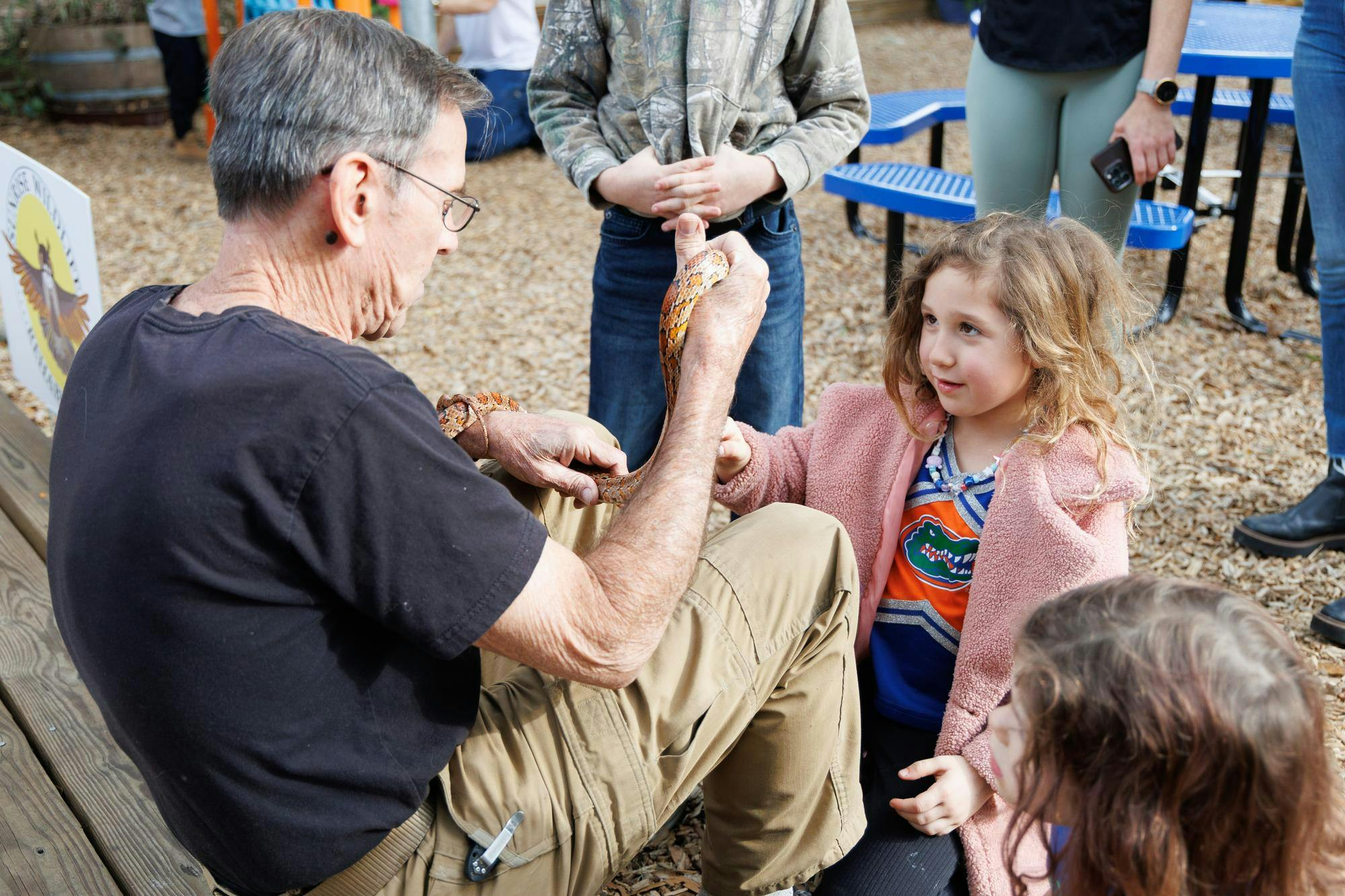 Sunrise Wildlife Rehabilitation director Joe Soistman holds Kernel, a corn snake, while Vanessa pets the snake at the Florida Master Naturalist Program’s 25-year anniversary celebration in Gainesville, Fla., Saturday, Jan. 17, 2026.