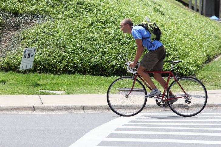 A commuter rides his bike east on Museum Road on Monday afternoon. A new study shows that biking to work can be healthier than regular exercise.