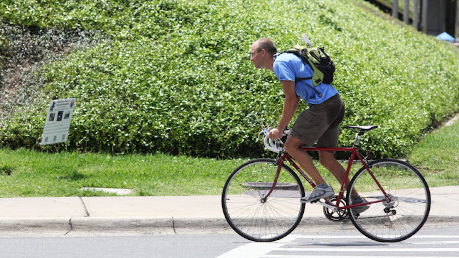A commuter rides his bike east on Museum Road on Monday afternoon. A new study shows that biking to work can be healthier than regular exercise.