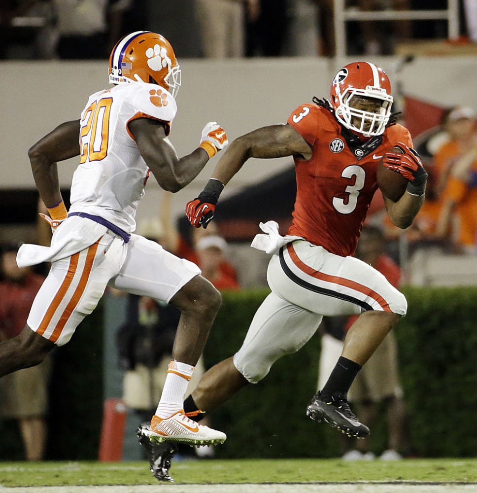 Georgia's Todd Gurley, right, runs the ball past Clemson's Jayron Kearse in the second half of an NCAA college football game in Athens, Ga. Gurley has been suspended for the last two games while Georgia investigated allegations he broke NCAA rules by receiving improper benefits.