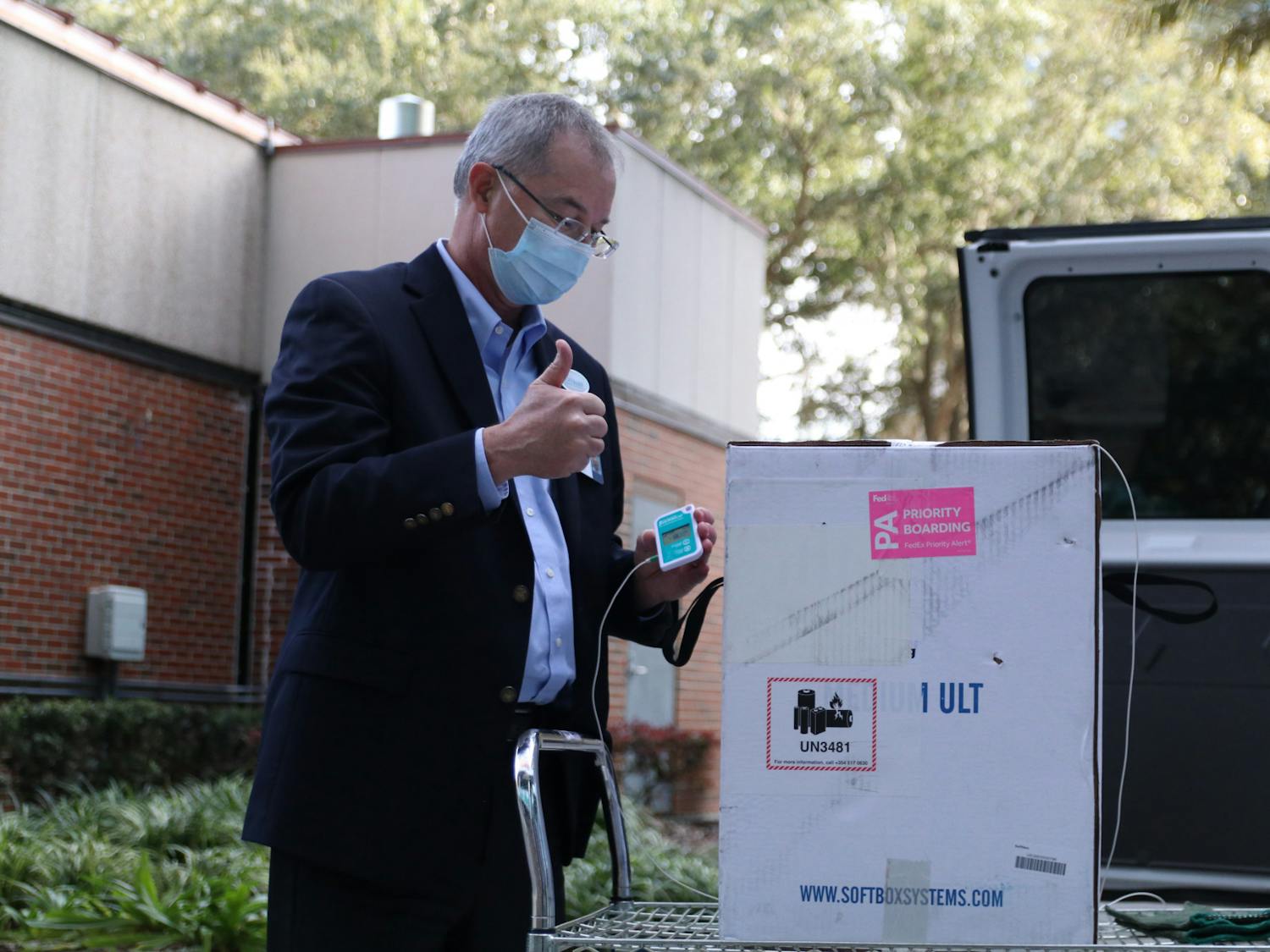 Thomas Johns, Director of Pharmacy Services at UF, gives a thumbs up after displaying the thermometer to the press. The Pfizer-BioNTech COVID-19 vaccine has to be stored at ultracold temperatures.