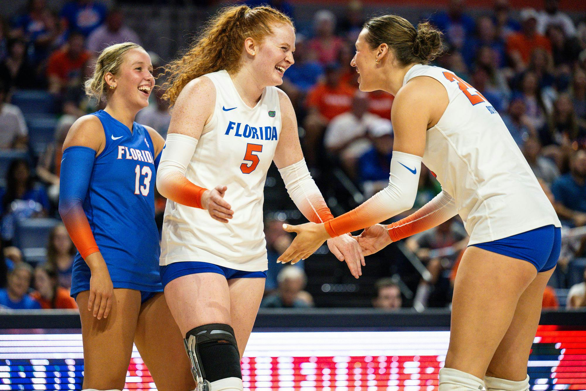 Florida Gators setter Alexis Stucky (5), middle blocker Alec Rothe (25) and libero/defensive specialist Lily Hayes (13) laugh together during a volleyball match against the Norfolk State Spartans on Sunday, Aug. 31, 2025, at the O'Connell Center in Gainesville, Fla.