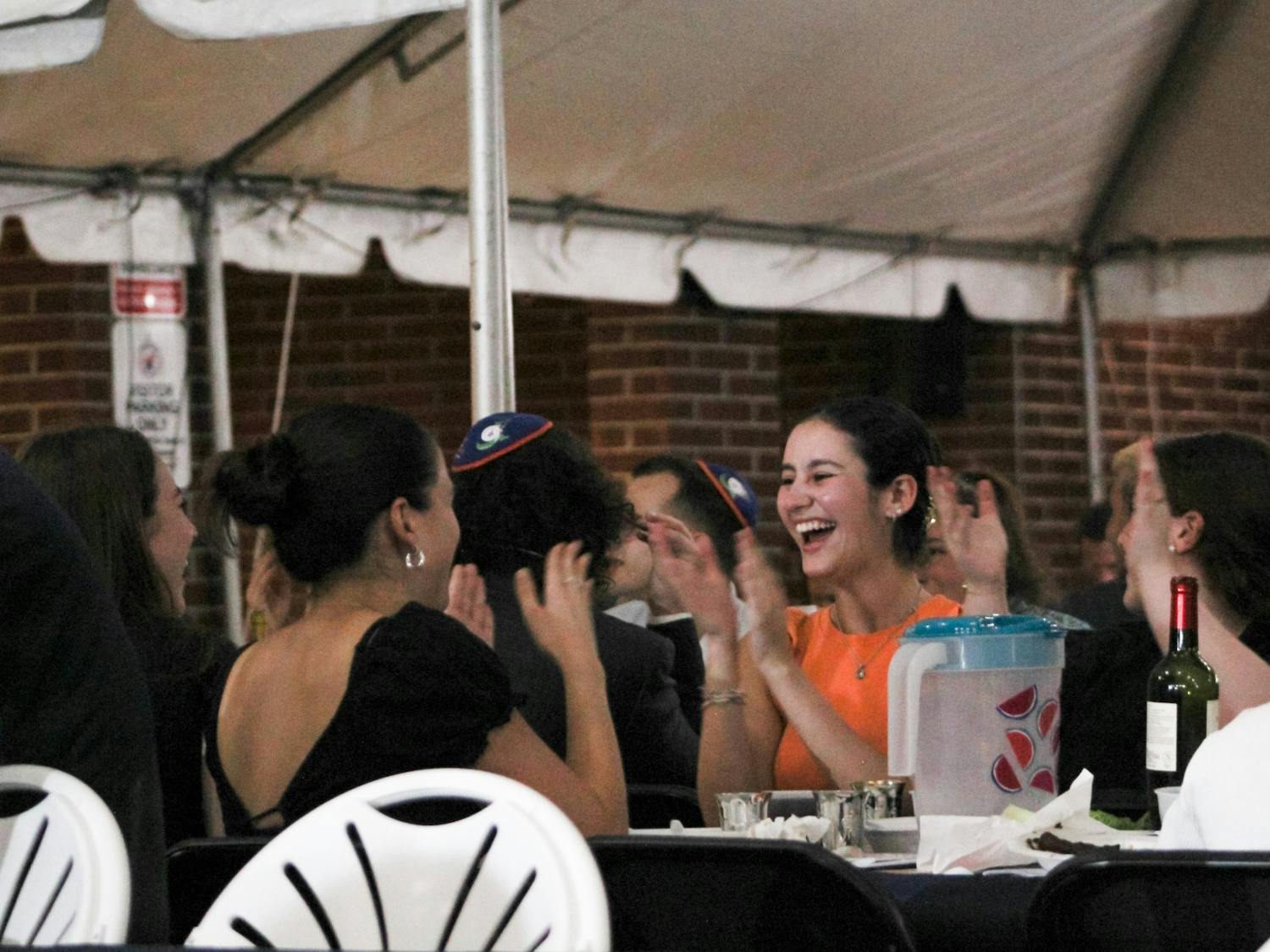 Students sing and clap after dinner during the Passover Seder﻿ at Lubavitch Chabad Jewish Student Center Wednesday, April 5, 2023.