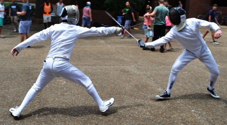 Get the point? - Gavin O'Leary (left), a 19-year-old nuclear engineering sophomore, and Eric Massa (right), a 20-year-old biology junior, duel on Turlington Plaza to recruit new members for the Fencing Team. The club has about 50 members, travels frequently and uses weapons called sabers, foils and epees.
