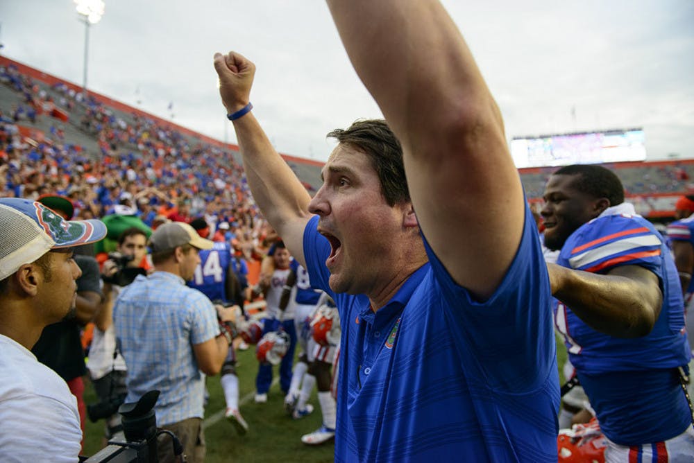 <p>Coach Will Muschamp celebrates following Florida's 65-0 win against Eastern Michigan on Saturday at Ben Hill Griffin Stadium.</p>