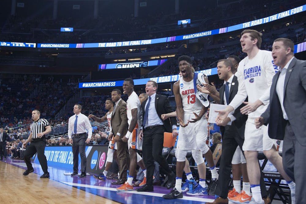 <p>UF players and coaches celebrate during Florida's 65-39 win against Virginia in the NCAA Tournament on Saturday in Orlando.&nbsp;</p>