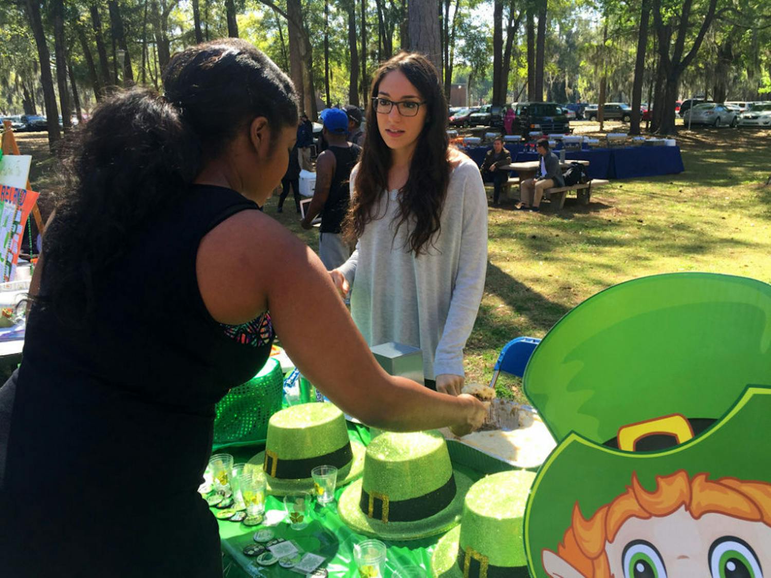 Kelsey Pena, right, the treasurer of UF’s Association of Public Interest Law, serves a student shepherd's pie, which was part of the Ireland table at the 10th Annual Multicultural Fair at the Levin College of Law on Tuesday.
