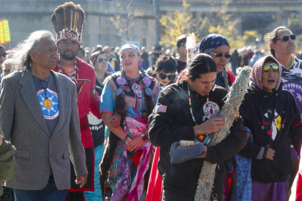 A group of indigenous peoples lead a march of protestors against fracking and shale gas through Point State Park before a ceremony to bless the three rivers, Wednesday, Oct. 23, 2019, in Pittsburgh. The group is protesting before President Donald Trump is to speak at at the Shale Insight Conference Wednesday afternoon. (AP Photo/Keith Srakocic)