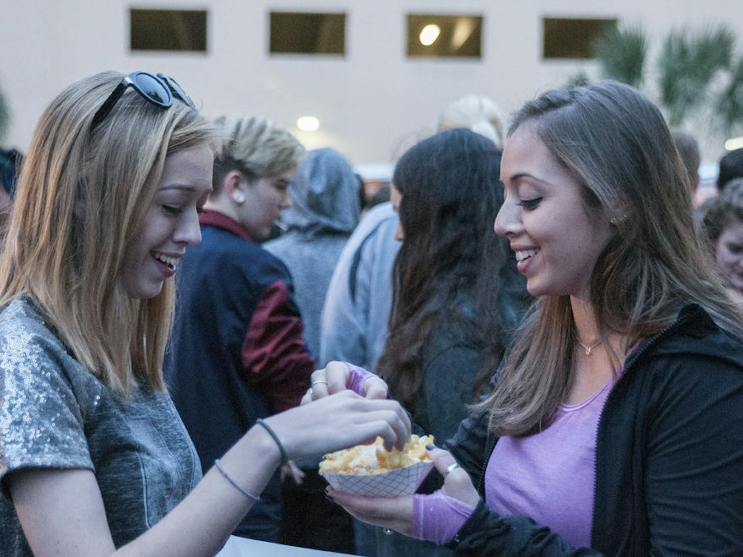 Esther (left), 17, and Emily O'Hearn, 27, share their fries at the third-annual Original Gainesville Food Truck Rally on Saturday