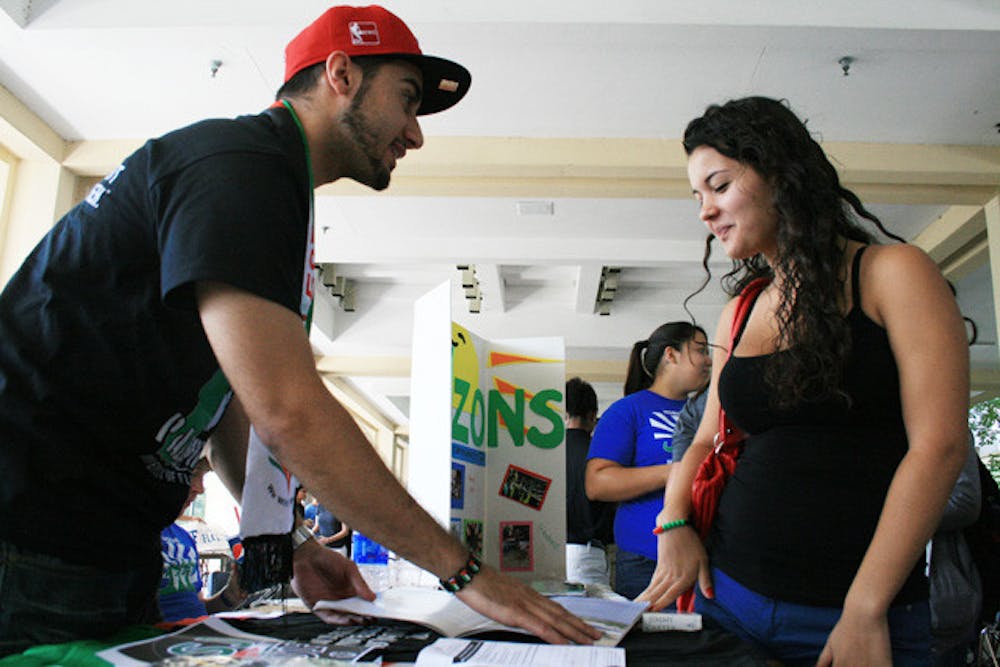 <p>Mohammad Tina, president of Students for Justice in Palestine, explains to Selina Batchanoo, first-year nursing student, about promoting peace in the Middle East. Tina says the club isn't political - it's humanitarian.</p>