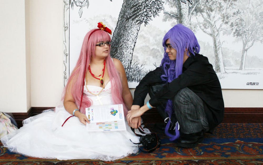 <p>Amy Bradley, left, a 23-year-old UF alumna, and James Hamlin, right, a 19-year-old engineering and Japanese freshman, dressed up as Vocaloids during the second-annual SwampCon, a multigenre convention, this weekend at the Reitz Union.</p>