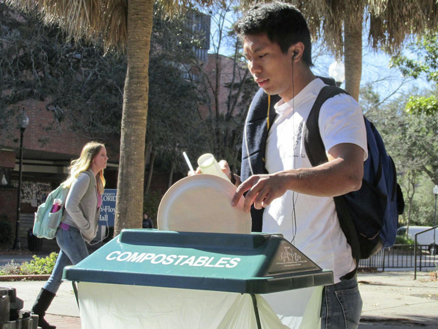 Jomar Duran, a 21-year-old UF psychology senior uses one of Krishna Lunch’s first compost trash cans on Plaza of the Americas on Jan. 11, 2016.