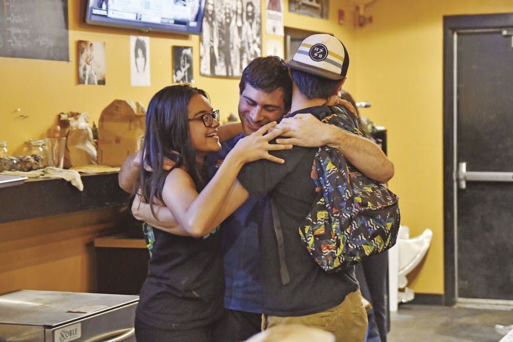 From left: Karla Arboleda, a 20-year-old UF journalism junior, Chase Dryer, a 22-year-old UF telecommunication senior, and William McDavid, a 19-year-old Santa Fe College pre-nursing sophomore, hug on Saturday evening.
&nbsp;