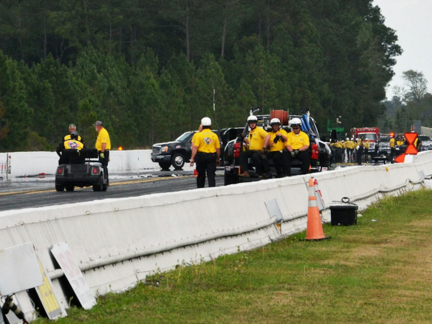 Emergency officials inspect the area near the finish line at Auto Plus Raceway in Gainesville following Top Fuel drag racer Larry Dixon's crash on Saturday at the 2015 Gatornationals.