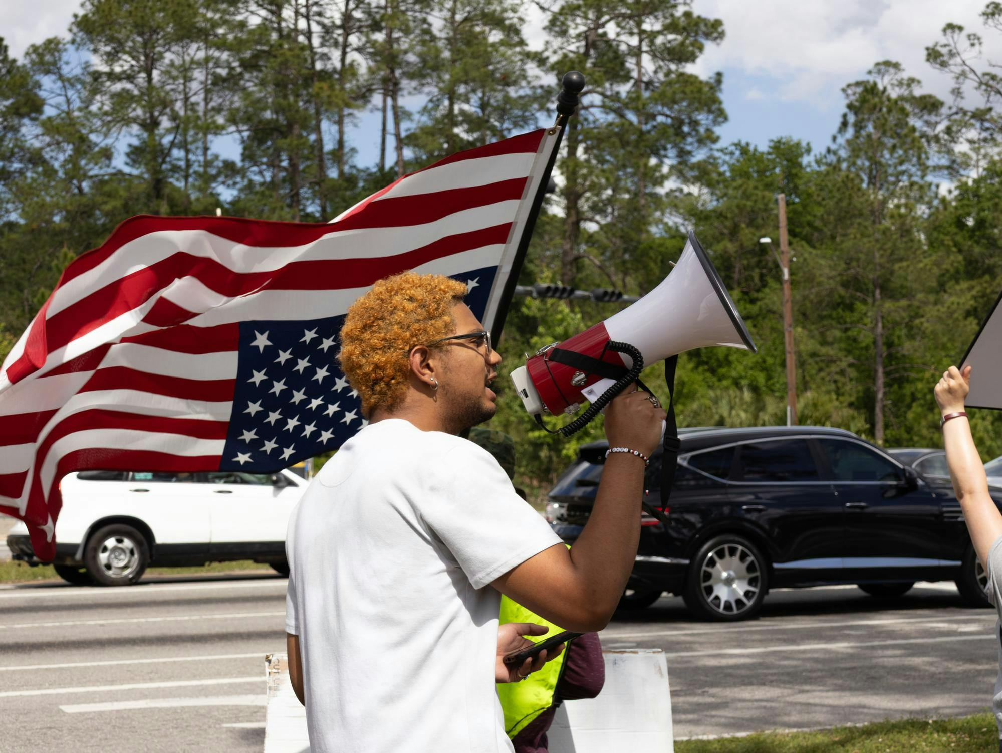 Protestors hold signs outside Florida Highway Patrol station, Friday, April 3, 2026, in Gainesville, Fla.