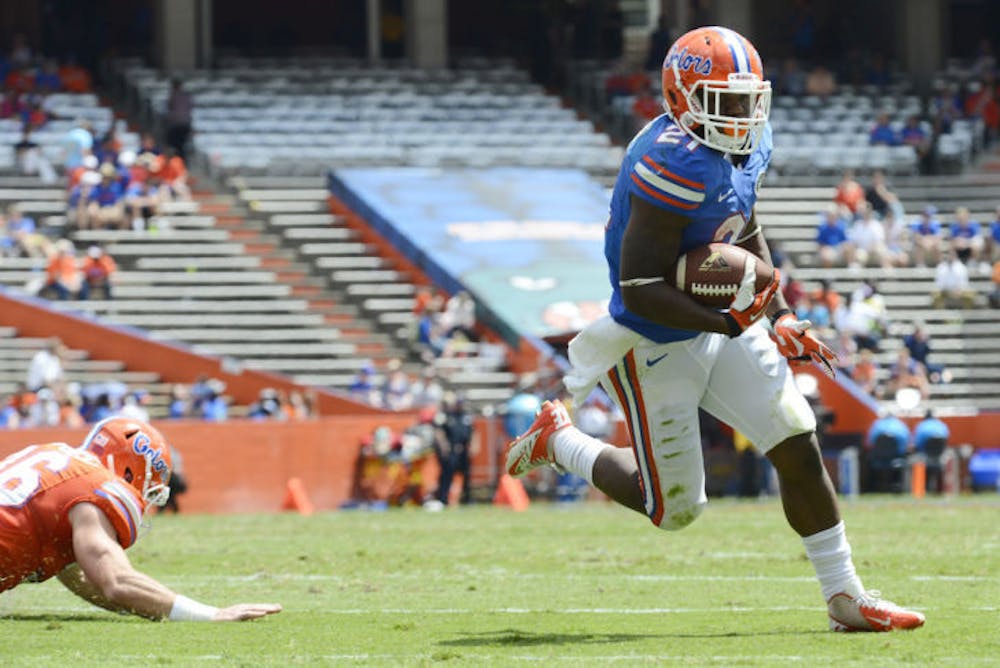 <p class="p1"><span class="s1">Freshman running back Kelvin Taylor (21) scores a touchdown during drills at the Orange and Blue Debut on Saturday at Ben Hill Griffin Stadium.&nbsp;</span></p>