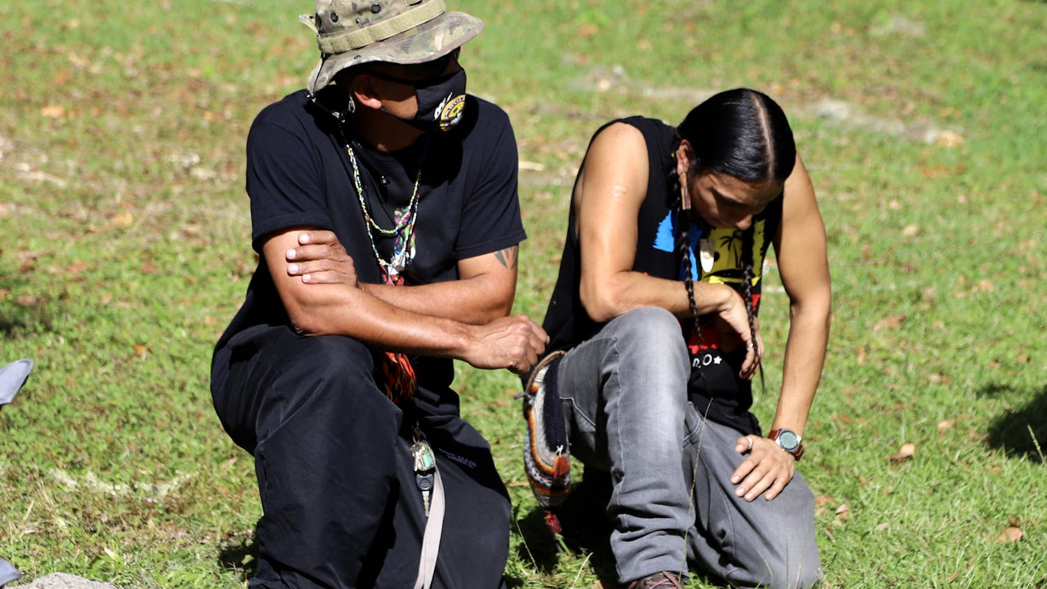 Robert Rosa (left), 52, a member of the Borinquen Taino nation and Stuart Flores (right), a member of the Algonquin Maya nation, kneel together, during the protest, in honor of their ancestors on Thursday, Dec. 3, 2020. The two explained that in Native American culture ancestors return to the soil after they pass away. 