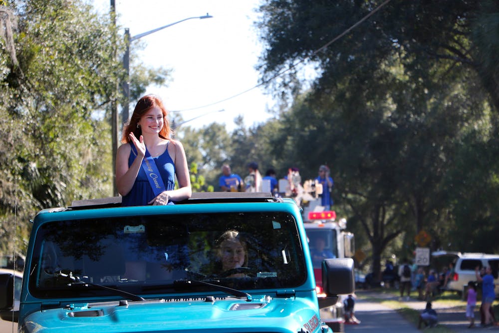 <p>Hannah Rone, 18, a senior at Newberry High School, waves to a crowd of people in the homecoming precession Friday, Oct. 14, 2022.</p>