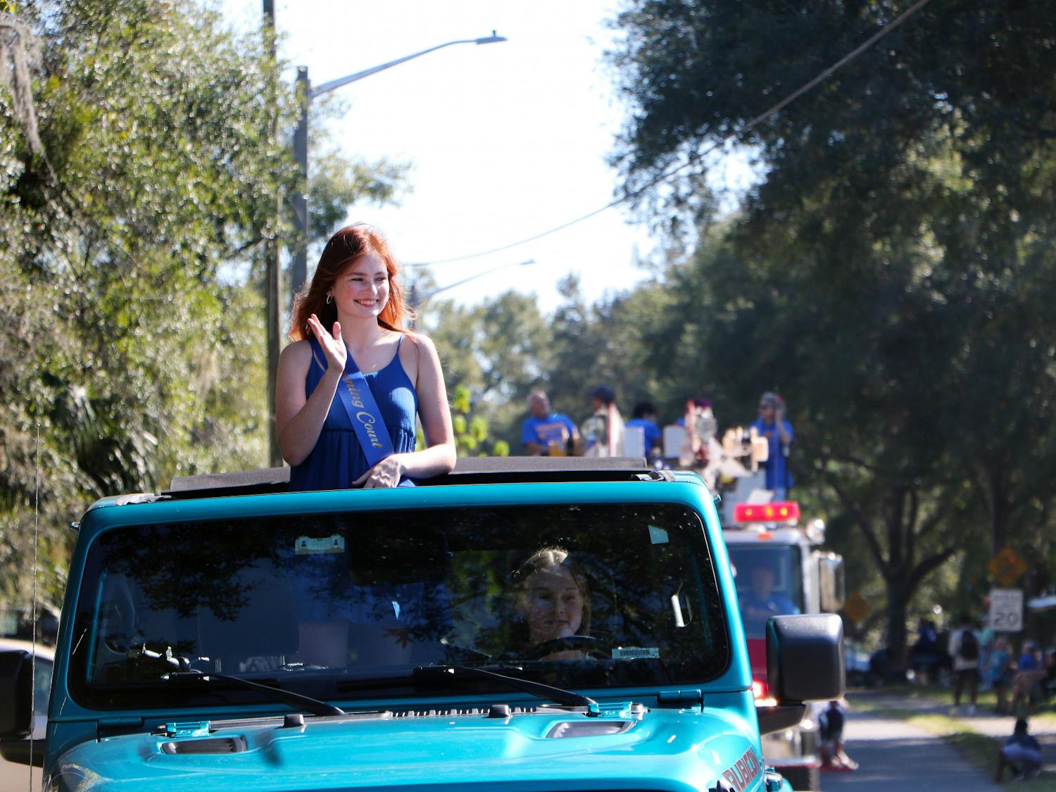 Hannah Rone, 18, a senior at Newberry High School, waves to a crowd of people in the homecoming precession Friday, Oct. 14, 2022.