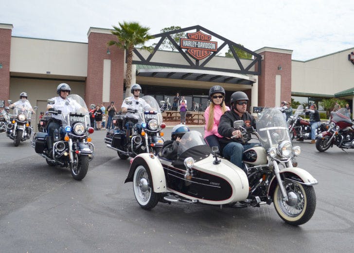 Marc Okes, 8, rides in the sidecar of Kevin Lytle’s Harley Davidson on Monday afternoon while his mother, Sandi Okes, rides on the back. Marc rode with about 200 motorcycles in a parade through Gainesville and High Springs.