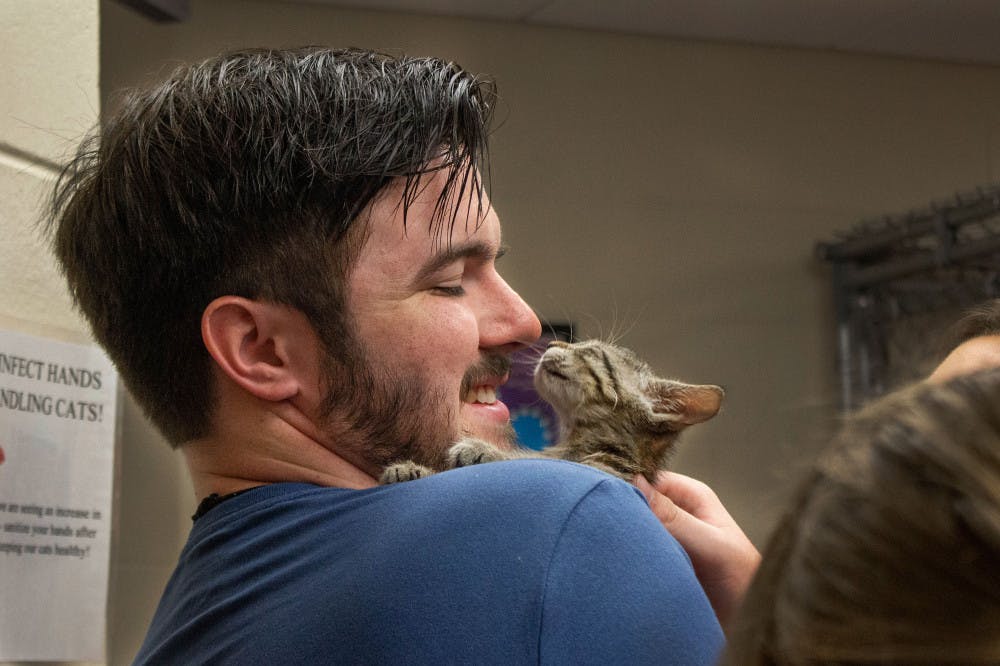 <p dir="ltr">Jacob Floyd smiles at his new 2-month-old kitten Saturday morning at the Summer Lovin’ Adopt-A-Thon.</p>
