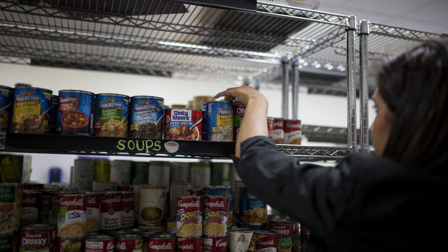 A volunteer stocking shelves with canned food at the Field and Fork Pantry on UF's campus in 2016.