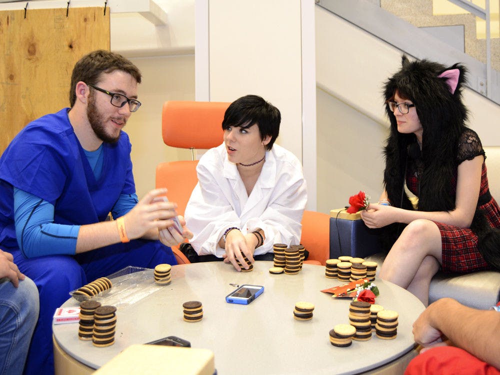 Jacksonville resident Josh Sutton (left), 21, and Newberry residents Summer Sturgill, 17, and Elizabeth Edwards, 15, play blackjack with vanilla and chocolate sandwich cookies in the Reitz Union during Swampcon on Sunday.
