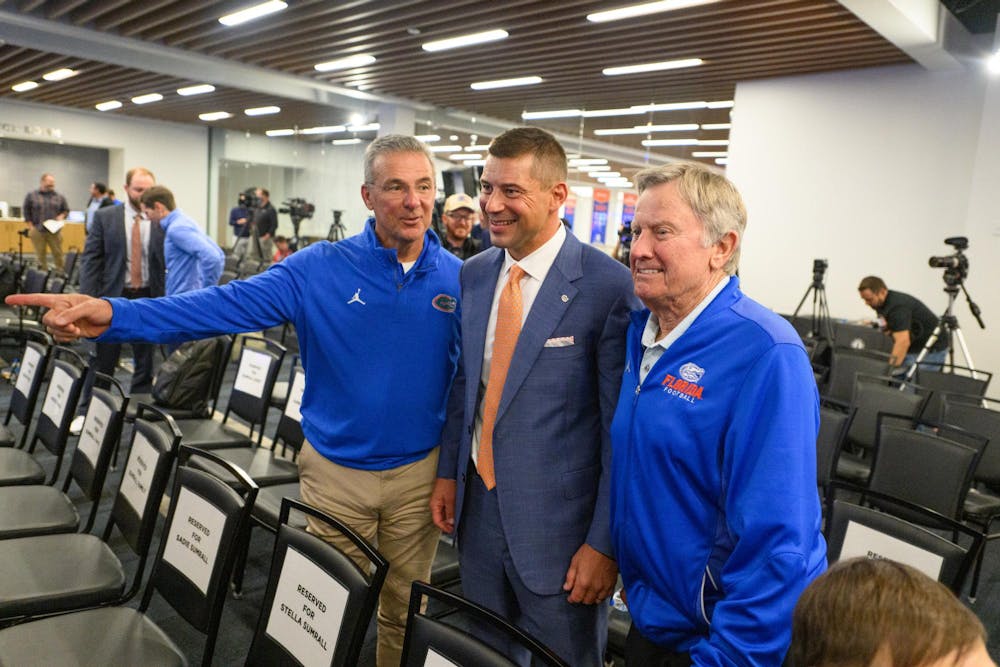 Former Florida head coaches Urban Meyer (left) and Steve Spurrier (right) pose for a photo with head coach Jon Sumrall (center) after his introductory press conference at Heavener Football Training Center in Gainesville, Fla., Monday, Dec. 1, 2025.