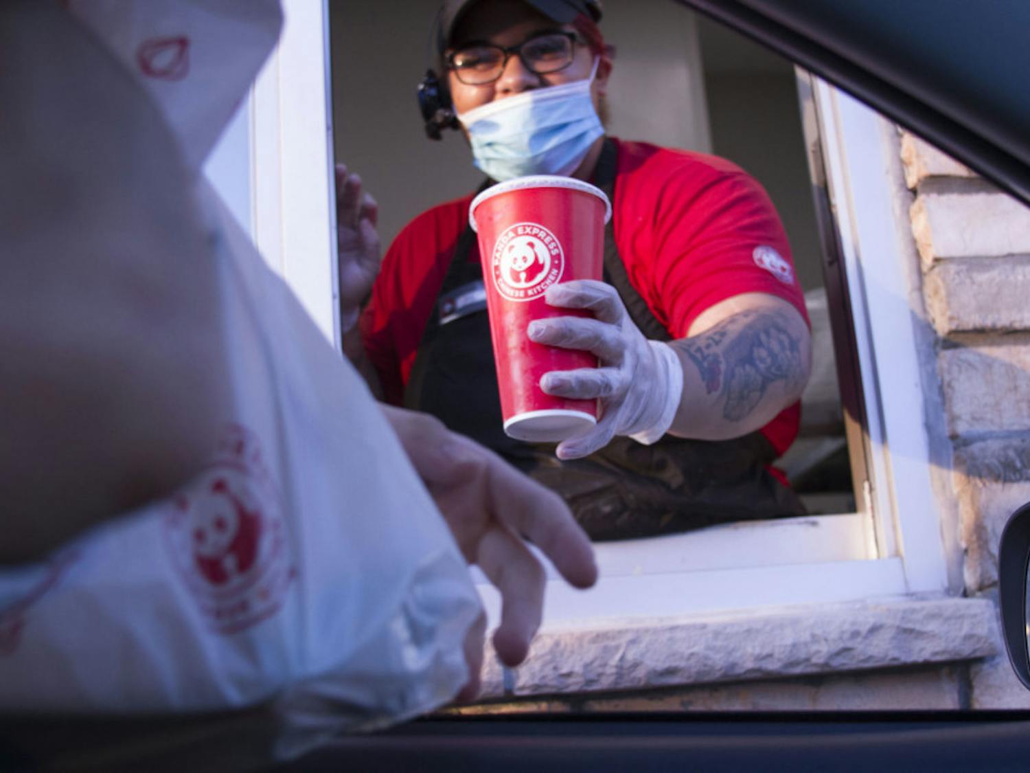 Kya Johnson, 19, passes food to a drive-thru customer. 