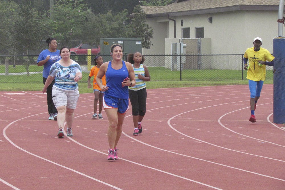 <p>Kourtney Oliver (center), the program coordinator for the Healthiest Weight Florida initiative in Alachua County, runs in the inaugural World Heart Day 5K event at Fred Cone Park on Sept. 26, 2015. Forty-seven people registered to run to raise awareness for heart disease and stroke prevention.</p>