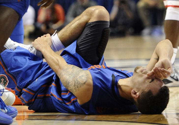 Scottie Wilbekin lies on the floor injured during the second half of No. 15 Florida’s 65-64 loss to No. 12 Connecticut on Monday in Storrs, Conn. Wilbekin is out indefinitely with a high right ankle sprain.