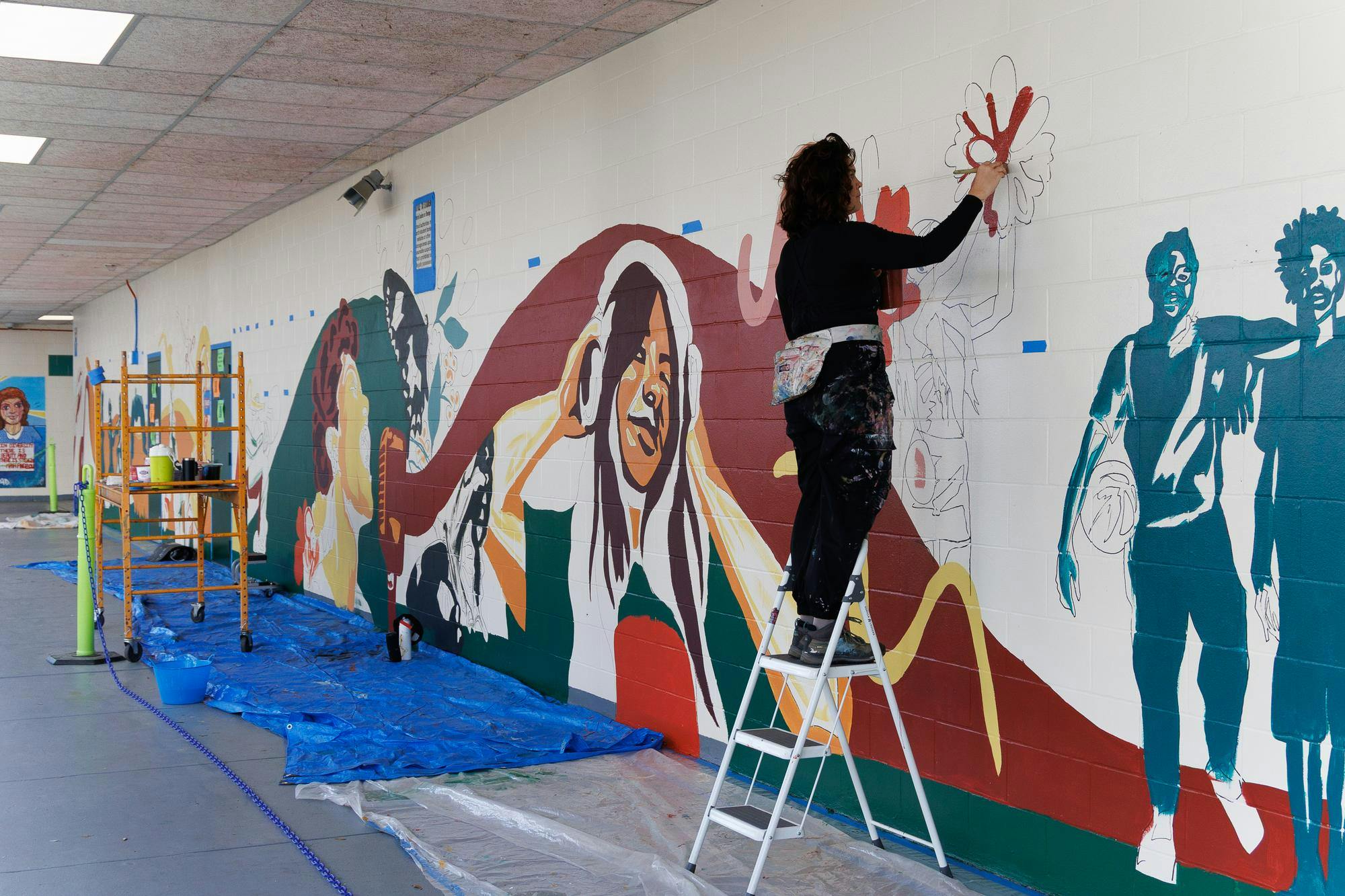 Jenna Horner, program director of Mindful Messages, paints a mural at East Side High School in Gainesville, Fla., Wednesday, March 11, 2026. 
