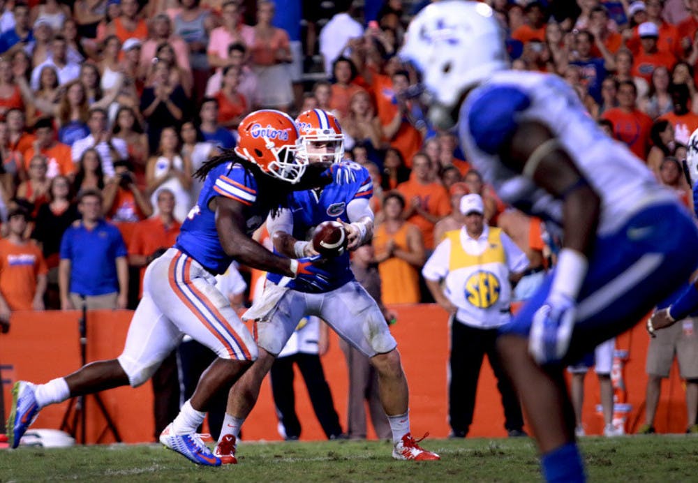 <p>Redshirt junior quarterback Jeff Driskel hands the ball to junior running back Matt Jones during Florida's 36-30 overtime victory against Kentucky on Saturday at Ben Hill Griffin Stadium.</p>