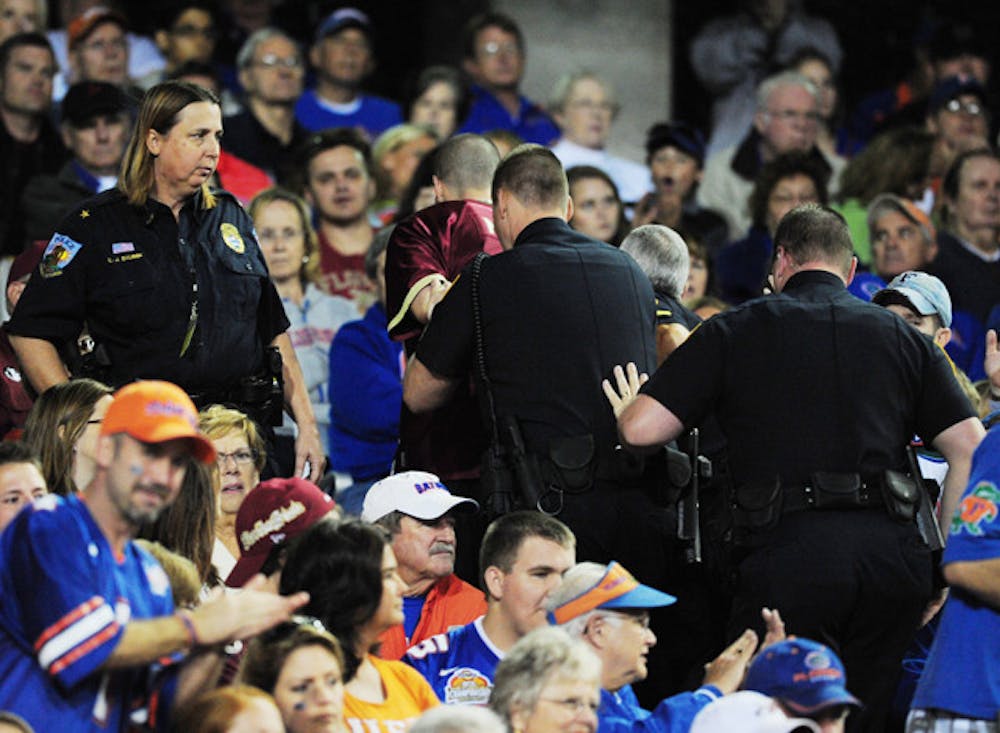 <p>An FSU fan is handcuffed and escorted out of Ben Hill Griffin Stadium during Saturday's game.</p>