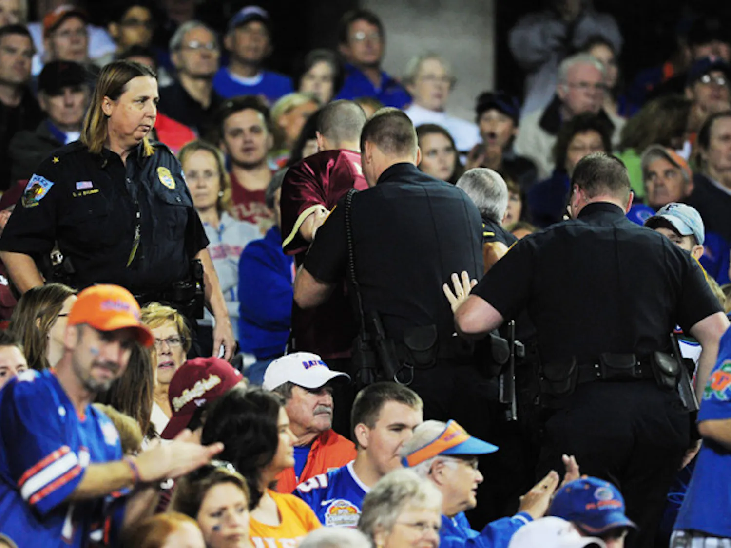 An FSU fan is handcuffed and escorted out of Ben Hill Griffin Stadium during Saturday's game.