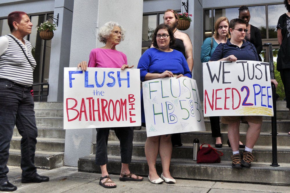 From left: Ellen Allen, 68, Shirley Roseman, 25, and Krys Davis, 28, hold signs outside of city hall on Monday morning protesting HB 583, which would require that single-sex public bathrooms only be used by persons of the biological sex the facility is intended for. "Everyone deserves to live their lives in a positive, equal way," Allen said.