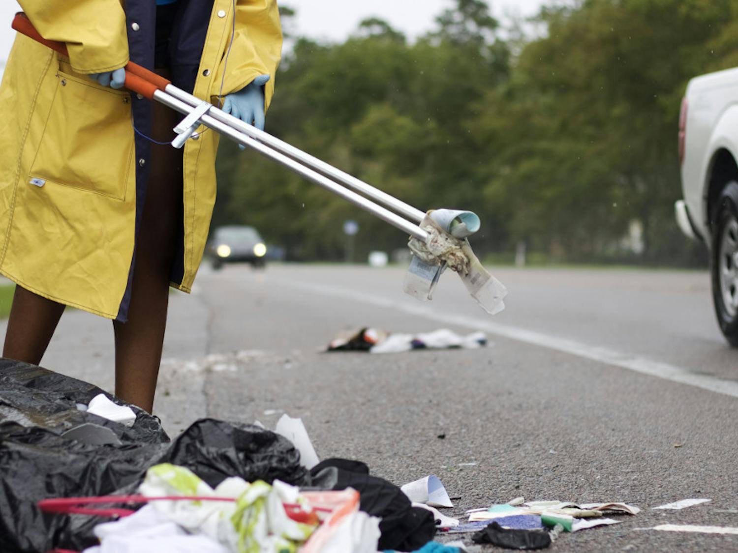 A community service volunteer picks up litter along SW 20th Avenue Aug. 19.