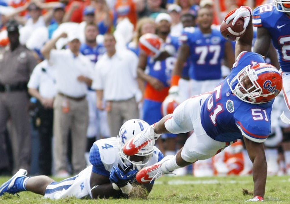 <p>Sophomore linebacker Michael Taylor goes to the ground after intercepting a pass thrown by Morgan Newton against Kentucky at Ben Hill Griffin Stadium on Saturday. Florida extended its winning streak against the Wildcats to 26 games.</p>