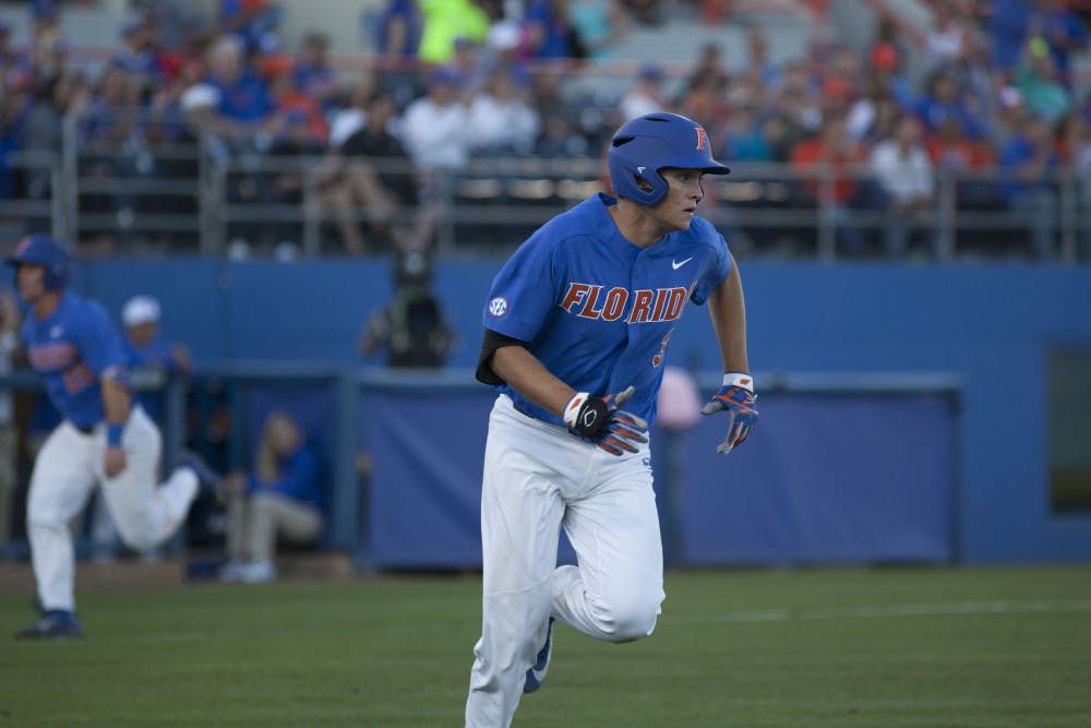 <p>UF infielder/pitcher Garrett Milchin runs towards first base after getting a hit during Florida's 3-2 loss against Tennessee on April 8, 2017, at McKethan Stadium.</p>