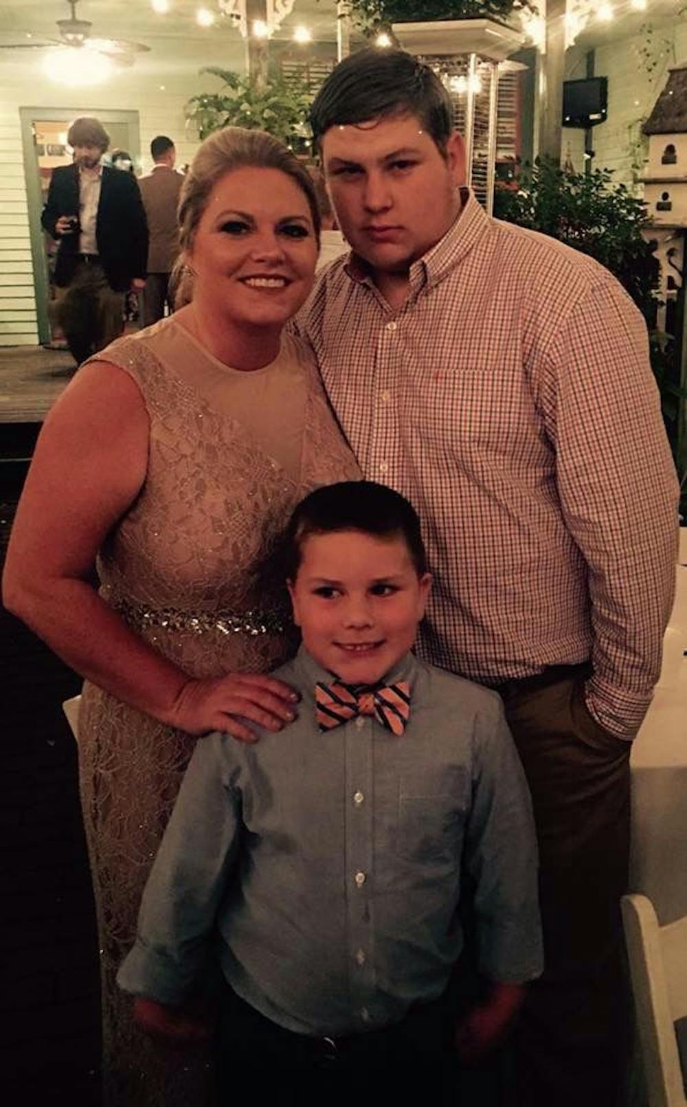 <p>Carla Collins, the first patient to receive a new $24,000 life-saving device, stands with her two sons, Brody, 8, and Chase, 18. Collins said she carries the gene for Long QT Syndrome, a life-threatening heart-rhythm condition, which causes fast heartbeats that can trigger fainting, seizures and sudden death. Both of her children will need to be tested for it as well.</p>