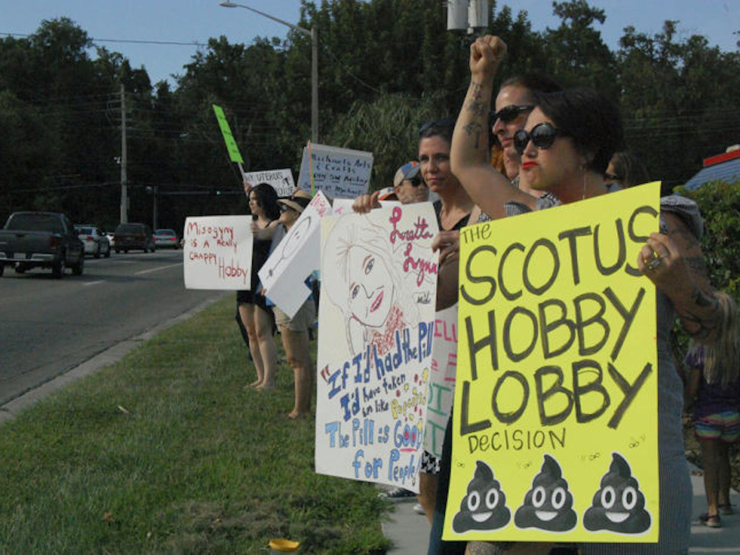 Members of the Gainesville chapter of the National Organization of Women, National Women’s Liberation and Gainesville citizens protest the opening of Hobby Lobby next to the Oaks Mall on Friday. They waved signs on Southwest 62nd Boulevard to let their voices be heard about the Hobby Lobby v. Burwell decision.