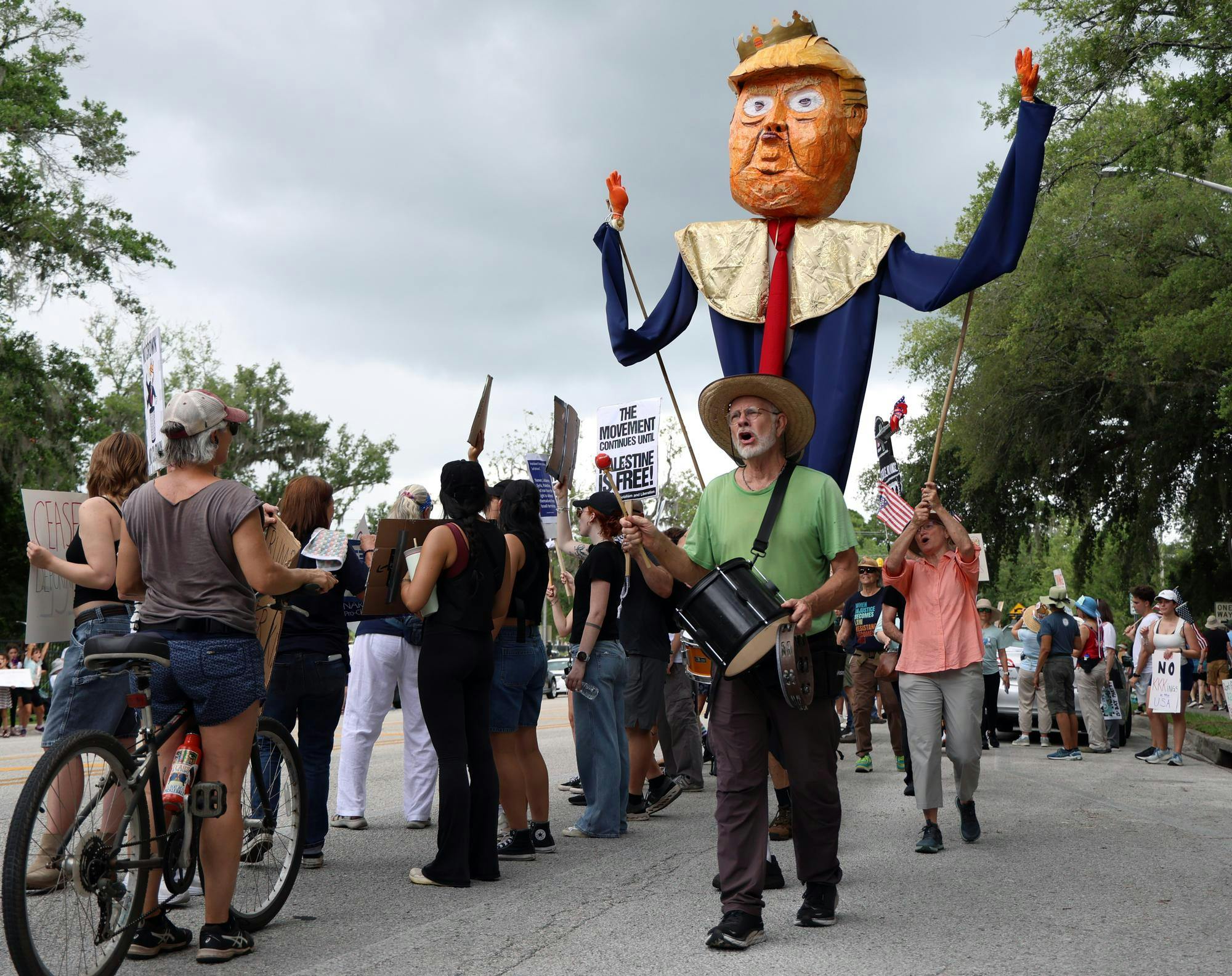 Protestors march with a paper-machete puppet of President Trump down Southwest Sixth Street during the "No Kings Day" protest on Saturday, June 14, 2025.
