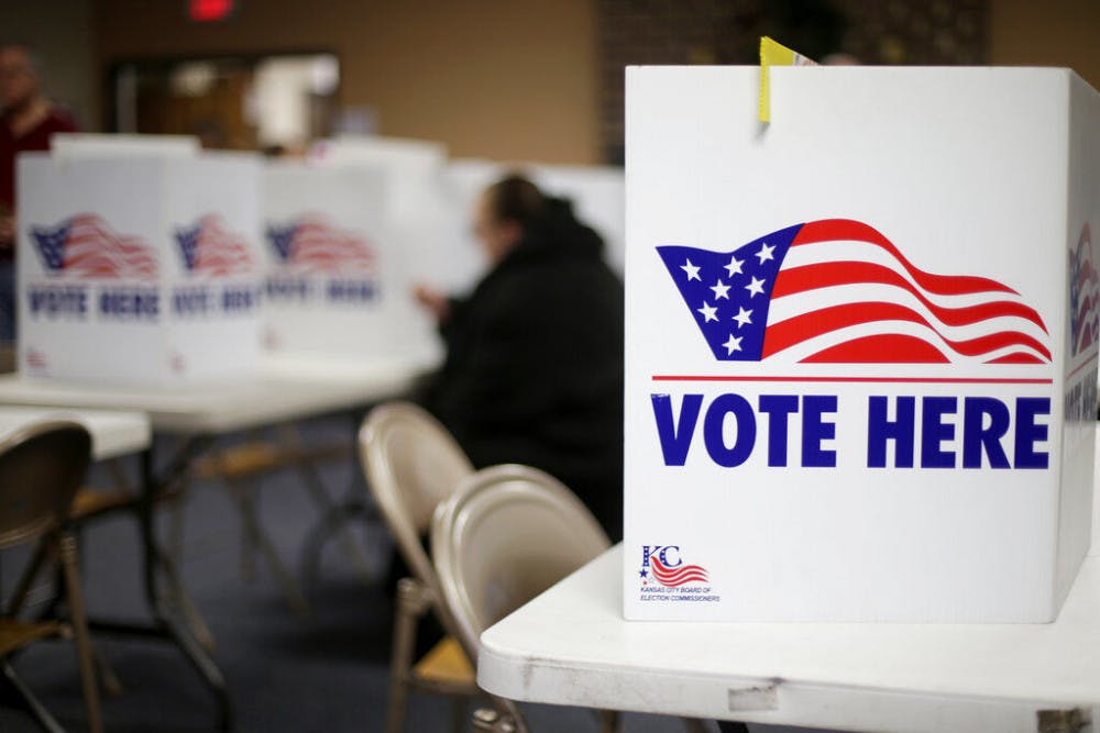 A woman votes in the presidential primary election at the the Summit View Church of the Nazarene Tuesday, March 10, 2020, in Kansas City, Mo. The polling place served two precincts as voters who were scheduled to vote at a nearby senior living facility were directed to vote at the church after the facility backed out due to coronavirus concerns. (AP Photo/Charlie Riedel)