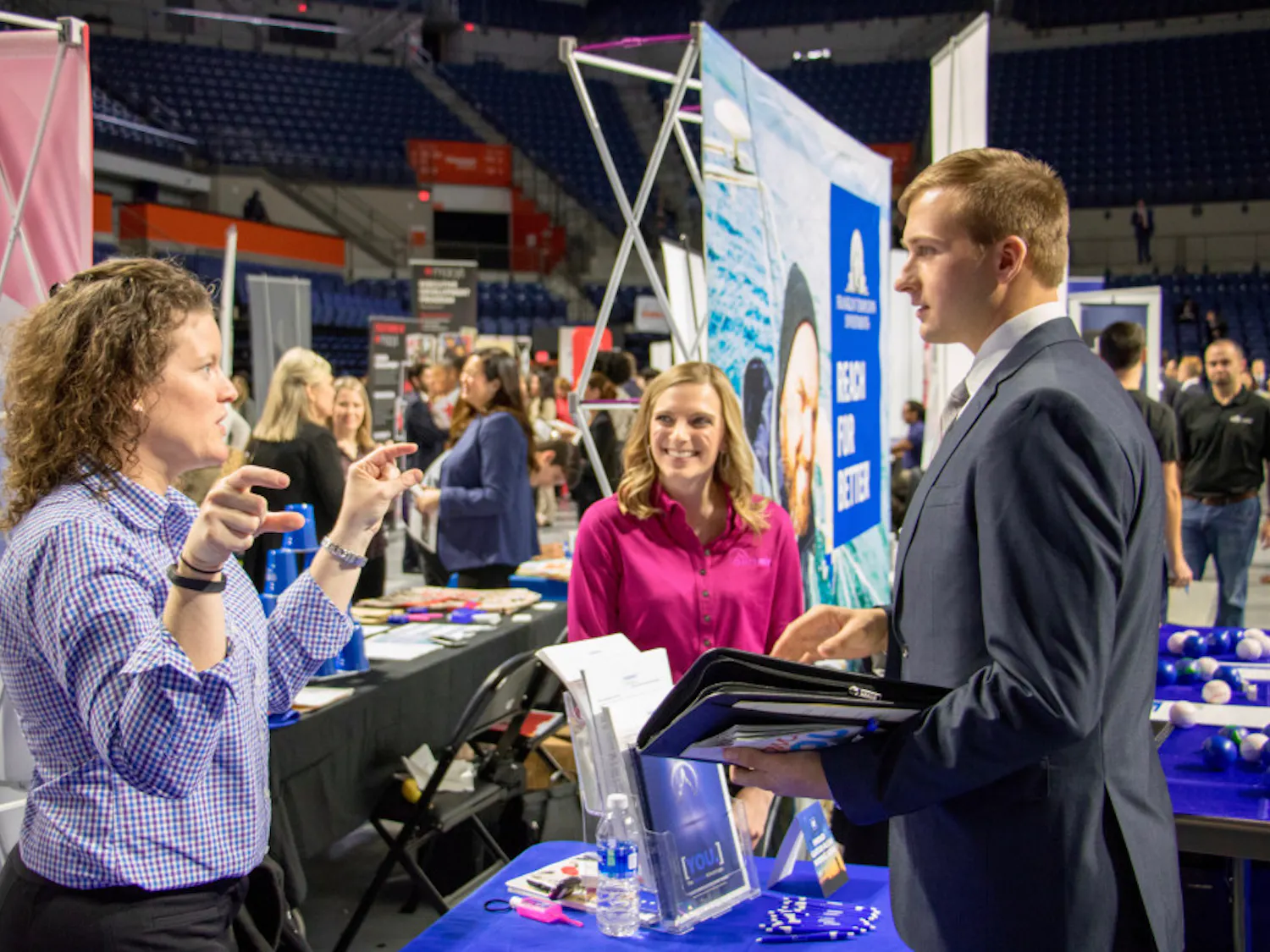 Representatives from Summit Holdings, Inc. speak to a student about the different opportunities at their company. Summit was one of the hundreds of firms and organizations present at Career Showcase in the Stephen C. O'Connell Center on Tuesday morning.