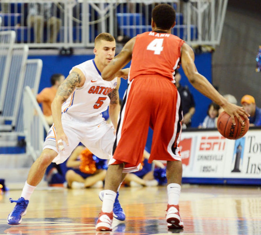 <p>Junior guard Scottie Wilbekin defends Georgia’s Charles Mann during Florida’s 77-44 win on Jan. 9 in the O’Connell Center.&nbsp;</p>