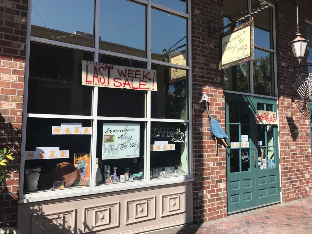 Somewhere Along the Way Art Gallery and Wine Cafe hangs up signs about its closing sale in its storefront.